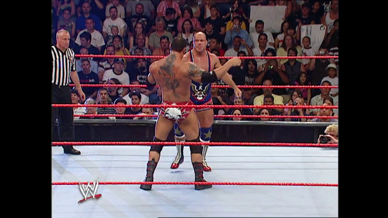 A frame from WWE Raw (June 20, 2005) at 1:17:13. A shirtless wrestler with extensive tattoos stands in a WWE Raw ring surrounded by red ropes, facing an opponent. A referee in a striped shirt watches from the side as a packed crowd fills the arena background.