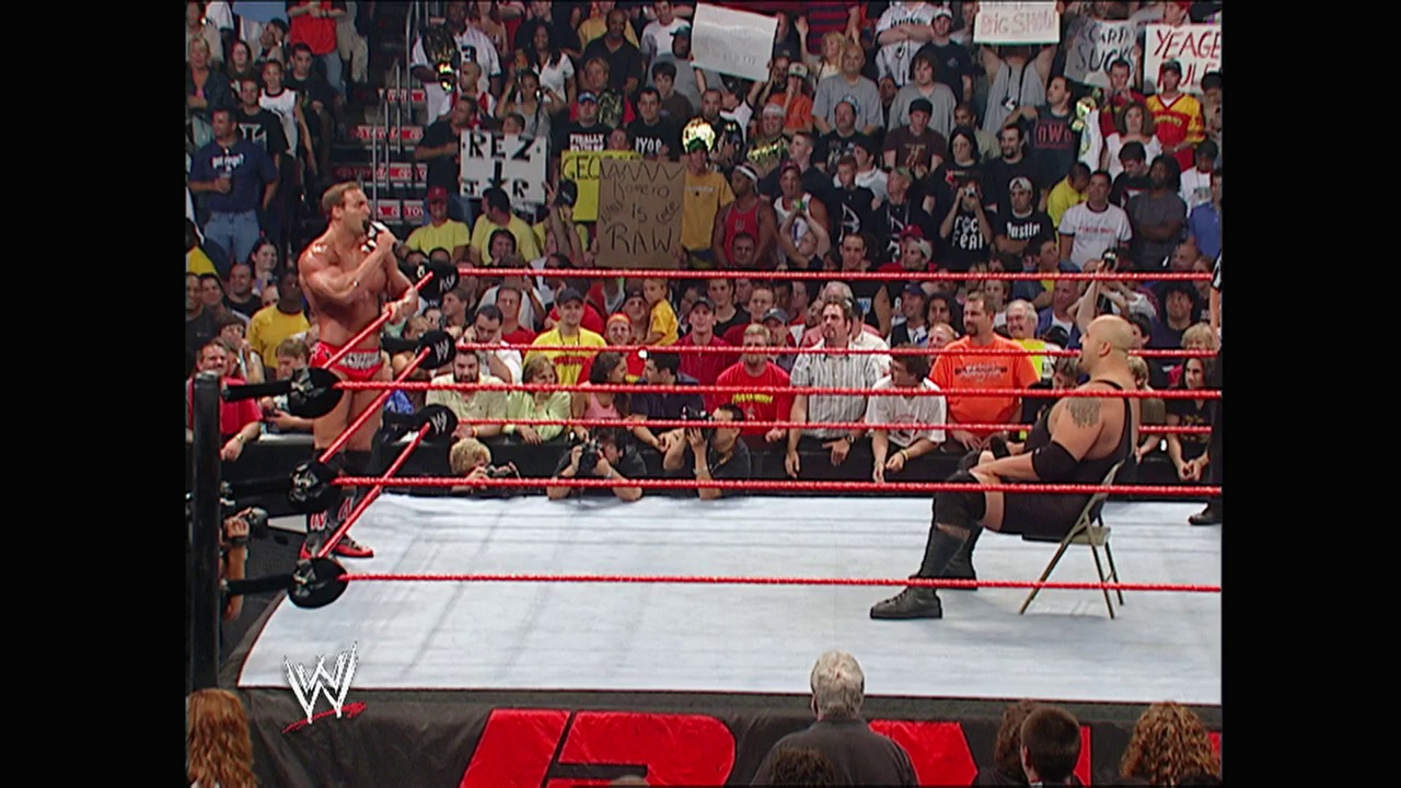 A frame from WWE Raw (July 18, 2005) at 40:24. A WWE wrestler performs an aerial maneuver from the top rope while another competitor waits in the ring. The crowd fills the arena around the red-roped wrestling ring, with visible signage and the WWE logo displayed.