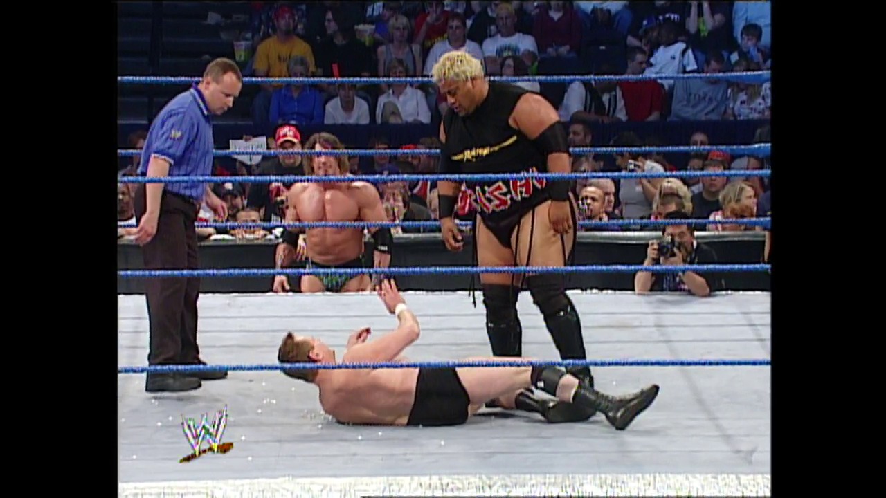 A frame from WWE SmackDown (April 24, 2003) at 37:42. A WWE wrestler lies on the mat while another stands nearby with the referee present. The blue-roped ring is surrounded by an engaged crowd, with the WWE logo visible in the lower left corner of the broadcast.