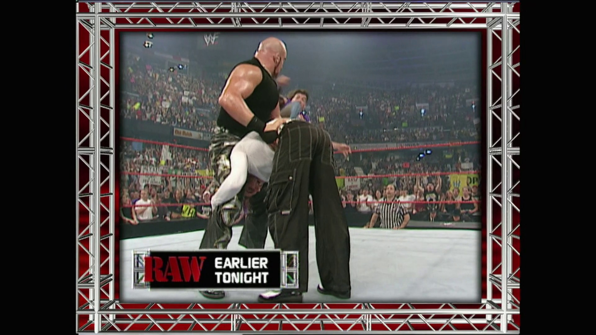 A frame from WWE Raw (May 28, 2001) at 55:13. A WWE Raw wrestler in a black sleeveless shirt executes a move on an opponent in dark pants within a packed arena. The crowd fills the background while a referee monitors the match, with "RAW EARLIER TONIGHT" displayed at the bottom of the screen.