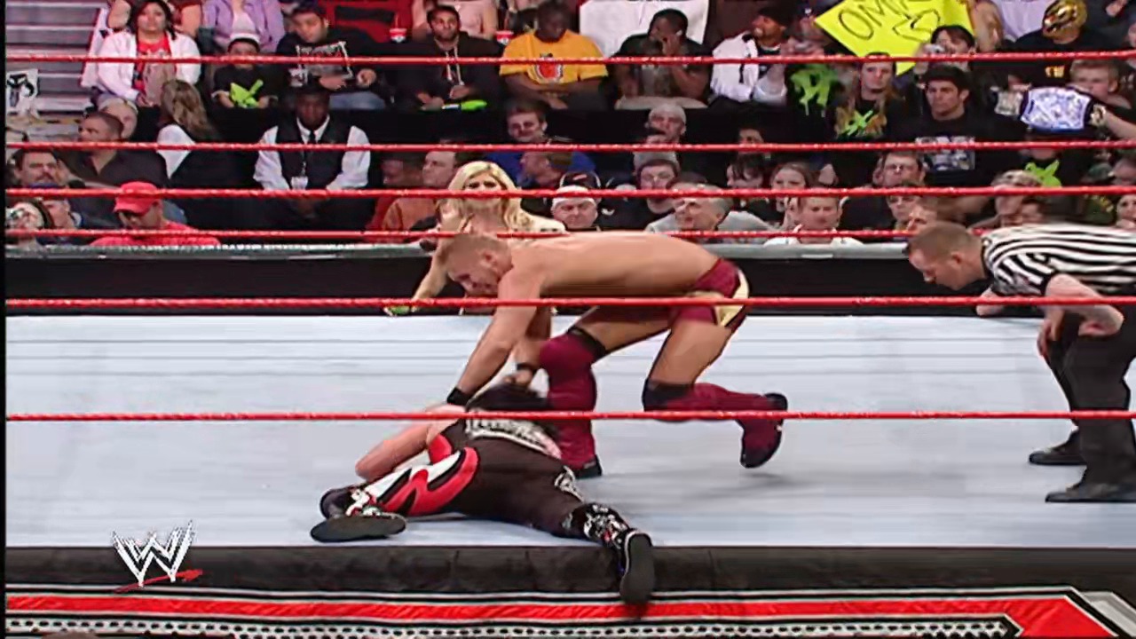 A frame from WWE Raw (January 29, 2007) at 50:16. A WWE wrestler in burgundy attire performs a move in the ring while an opponent lies on the mat, with a referee observing. The crowd fills the stands behind the red ropes, and the WWE logo appears in the bottom corner.