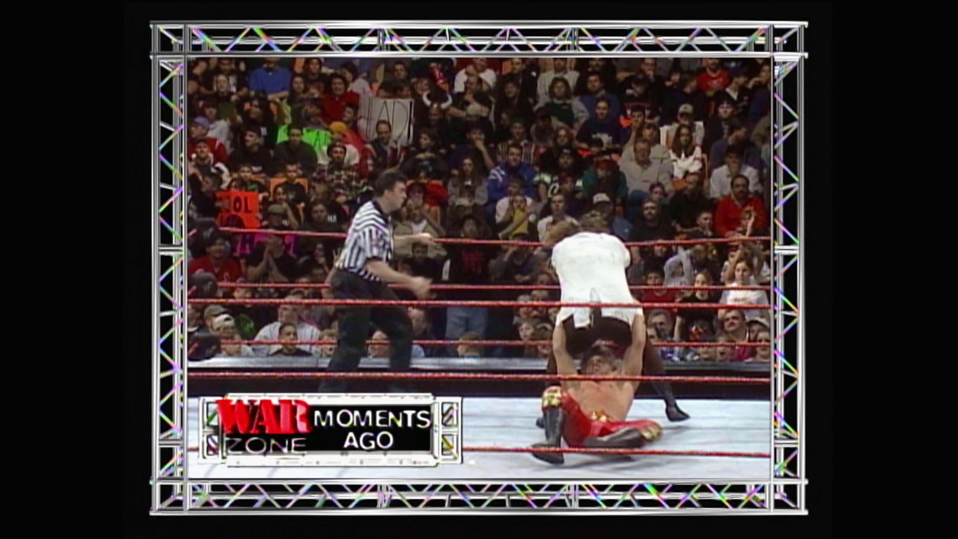 A frame from WWE Raw (January 4, 1999) at 50:46. A wrestler in white performs a headstand in the WWE Raw ring while a referee watches, with a packed crowd visible in the background. The frame includes "Raw Moments Ago" graphics and the distinctive red ropes and truss structure of the wrestling ring.