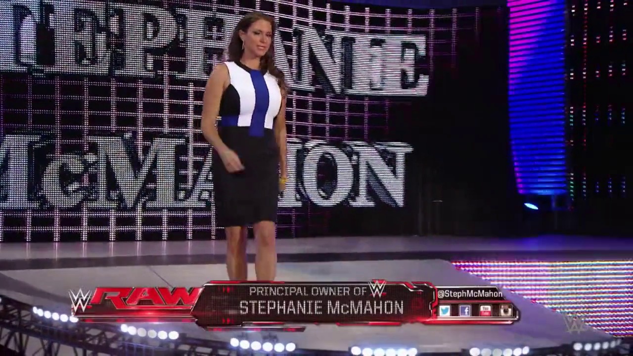 A frame from WWE Raw (July 13, 2015) at 41:24. A woman in a black and blue striped sleeveless dress stands on the WWE Raw stage with illuminated LED screens behind her. The lower third displays "Principal Owner of WWE - Stephanie McMahon" with her Twitter handle @StephMcMahon.