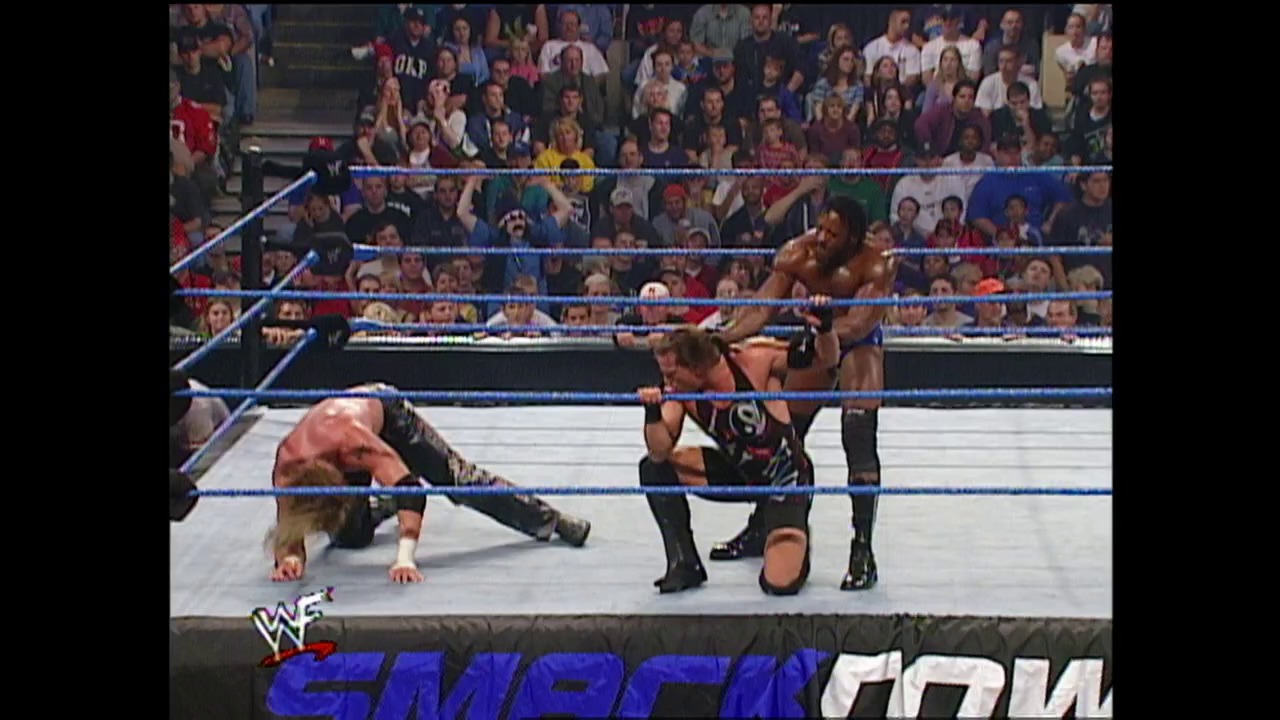 A frame from WWE SmackDown (October 25, 2001) at 26:39. A WWE wrestler lies prone on the mat while another stands nearby in the blue-roped ring, with a packed crowd visible in the stands. The WWF SmackDown logo appears at the bottom of the screen.