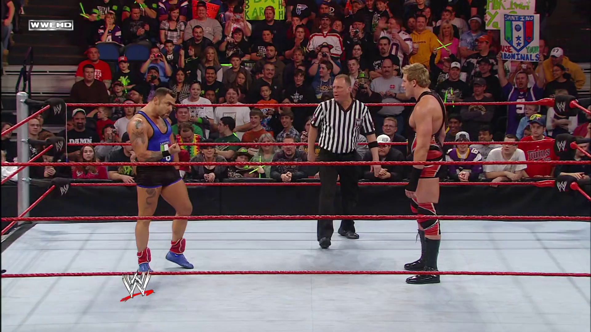 A frame from WWE Raw (January 11, 2010) at 40:05. # WWE Raw Match Scene

Two wrestlers face off in a WWE ring with red ropes, while a referee in black and white stripes officiates. A large crowd fills the arena background, with the WWE logo visible on the mat.
