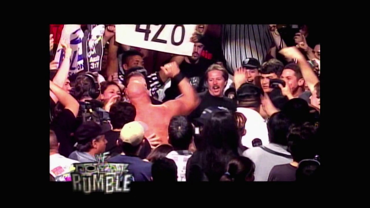 A frame from WWF Royal Rumble: No Chance in Hell (1999) at 2:42:14. # Visual Description

A shirtless wrestler celebrates in the center of a crowded ring surrounded by cheering fans and other performers. The "WWF Royal Rumble" logo is visible in the lower left corner of the broadcast.