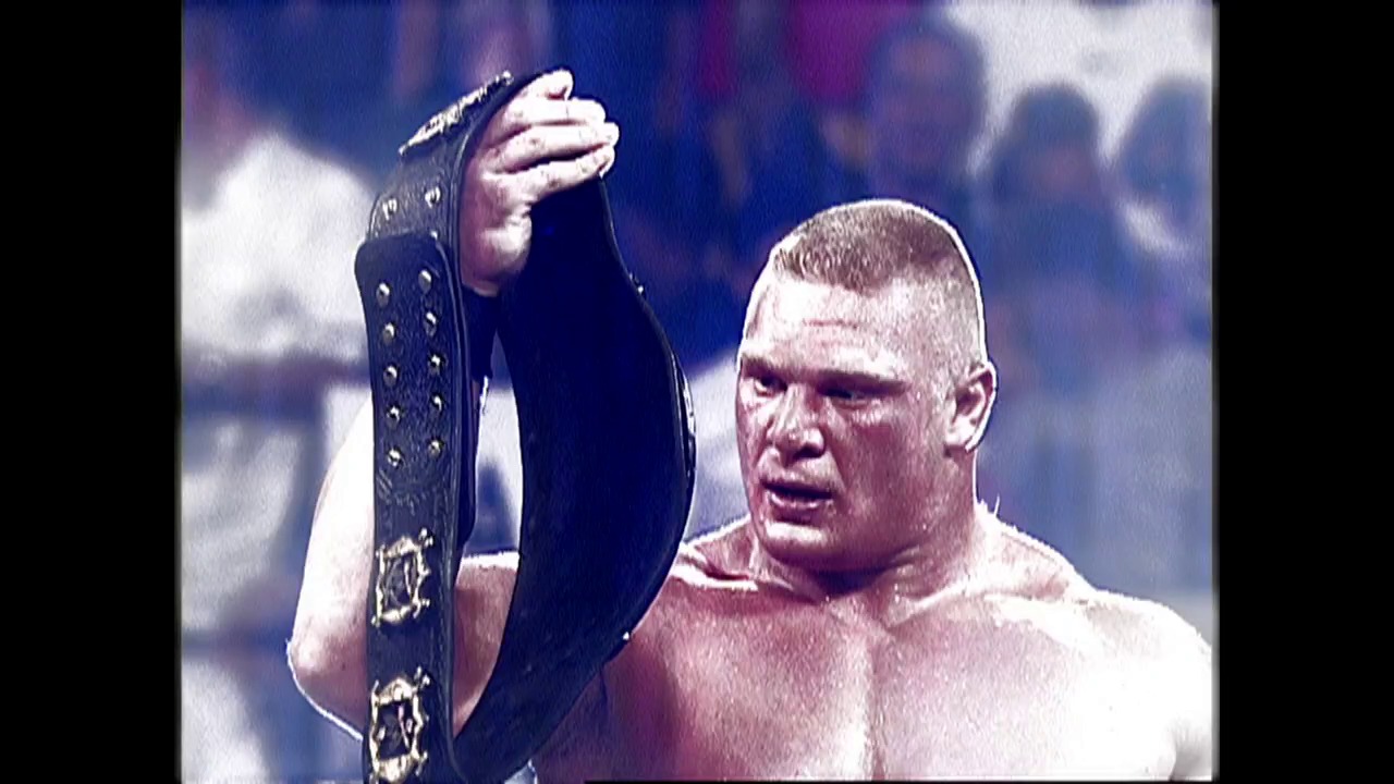 A frame from WWE Raw (August 29, 2002) at 0:30. A shirtless wrestler holds up a decorative championship belt above his head in the wrestling ring, with a blurred crowd visible in the background. The scene captures a moment of victory or celebration during a WWE Raw event.