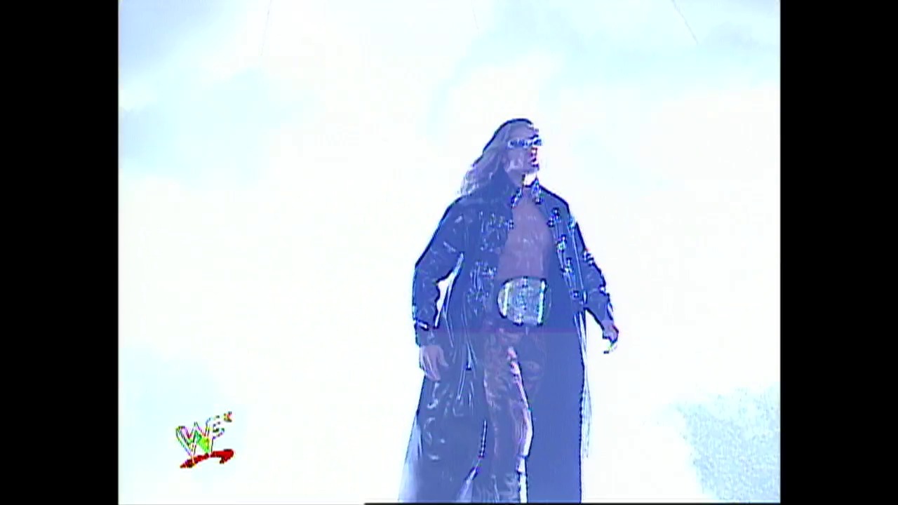 A frame from WWE Raw (January 17, 2002) at 59:42. A wrestler in a blue-tinted outfit stands against a light sky background during a WWE Raw broadcast from January 2002, with the WWE logo visible in the lower left corner of the screen.