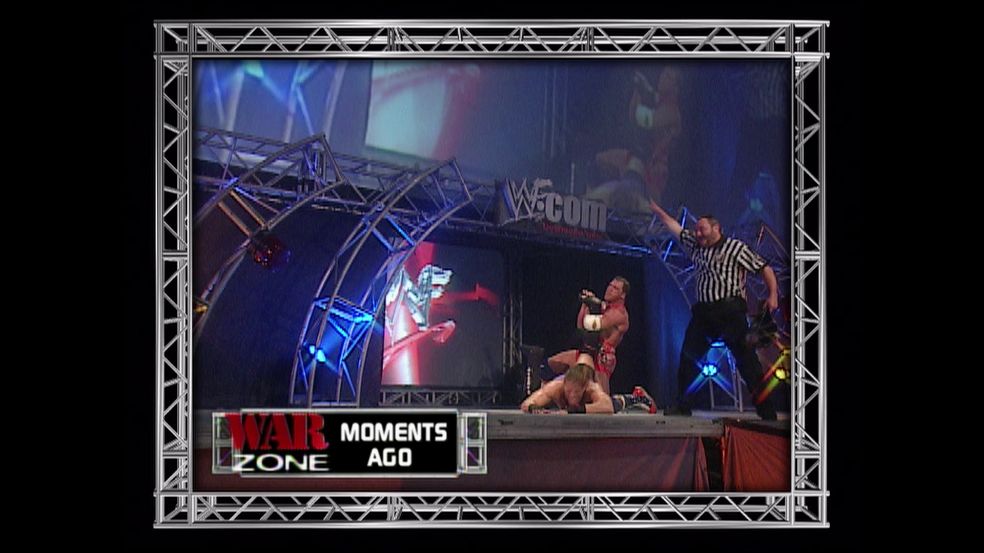 A frame from WWE Raw (September 10, 2001) at 1:23:32. A WWE wrestling match is captured mid-action in the ring, with a referee in a striped shirt overseeing two wrestlers. The "War Zone" graphics and blue metal stage structure are visible in the background, with the WCW logo on the backdrop.