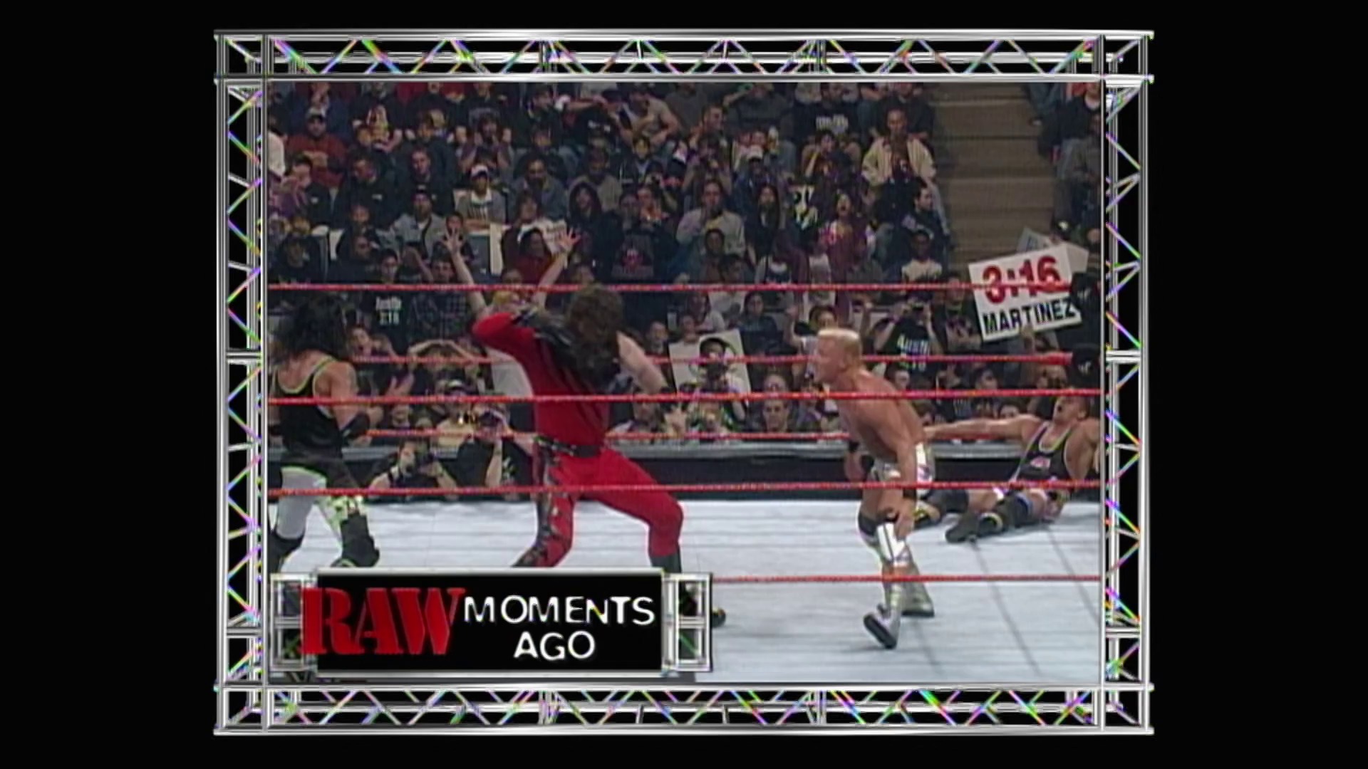 A frame from WWE Raw (April 5, 1999) at 14:05. A WWE Raw match in progress shows wrestlers in the ring with a packed crowd in the background. The broadcast displays "RAW MOMENTS AGO" graphics with a steel cage visible and a sign reading "346 MARTINEZ" in the upper right.