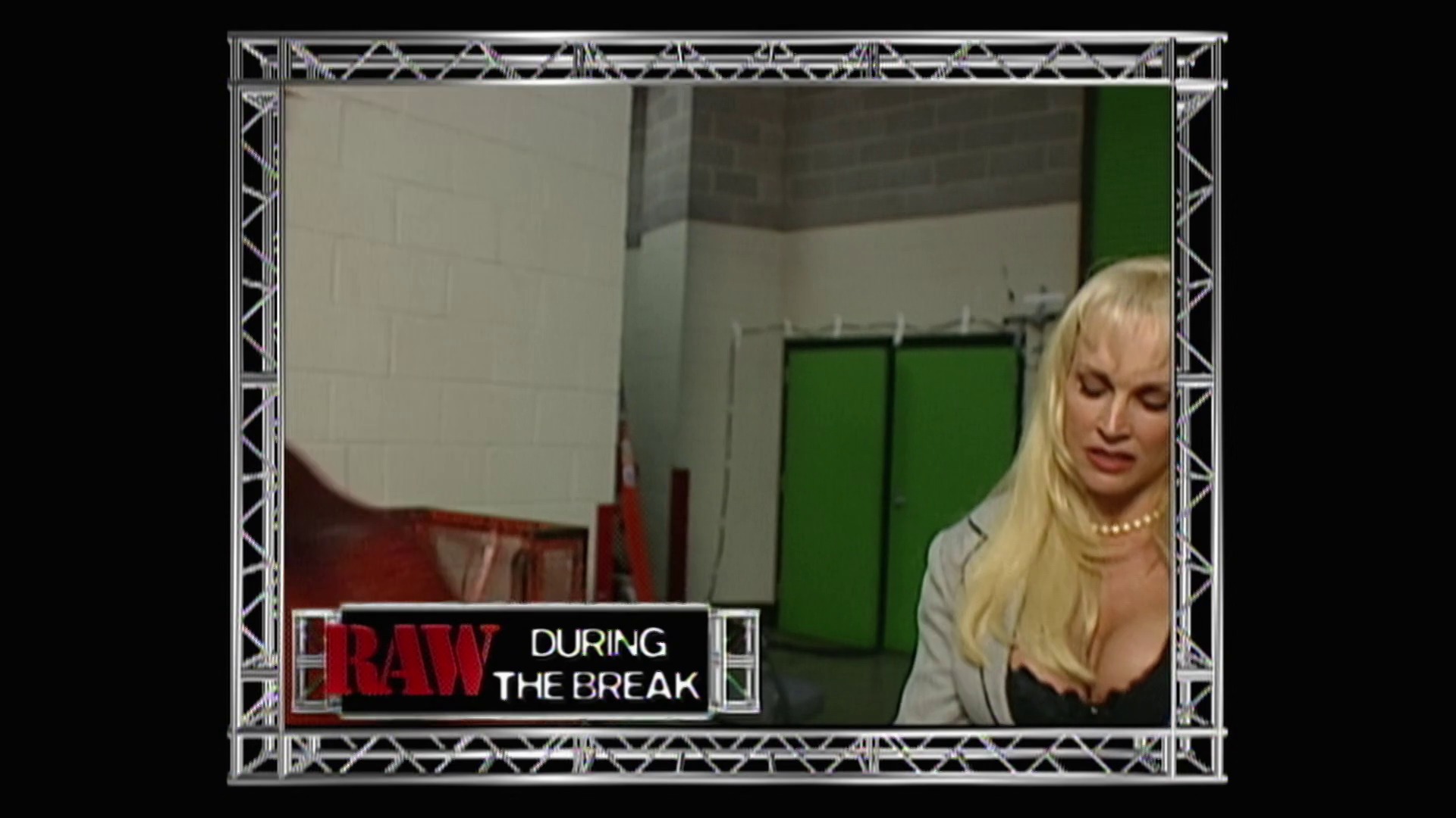 A frame from WWE Raw (July 19, 1999) at 41:46. A blonde woman in a light-colored top stands in a backstage area with green doors visible behind her. A "RAW DURING THE BREAK" graphic appears at the bottom of the frame, indicating this is footage from a WWE broadcast.