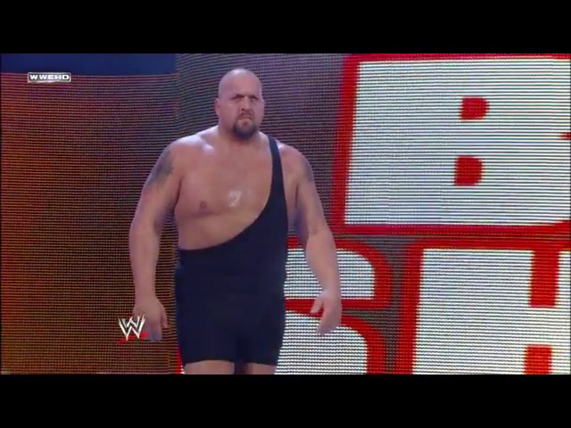 A frame from WWE Raw (March 17, 2008) at 1:05:20. A shirtless WWE wrestler stands on the entrance stage wearing black shorts, with the WWE logo visible in the lower left corner and red and white graphic elements displayed on the screen behind him during a televised Raw event.