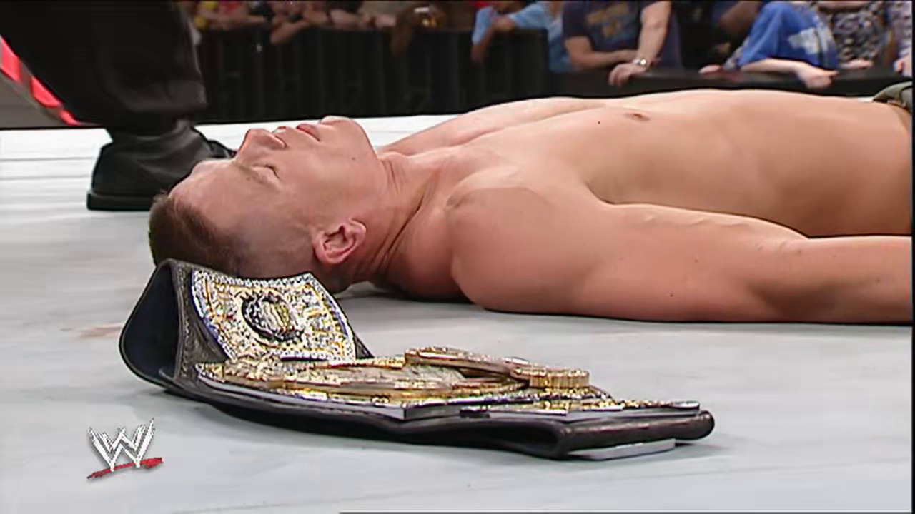 A frame from WWE Raw (April 30, 2007) at 1:28:52. A shirtless wrestler lies on the WWE ring mat next to a championship belt, with the crowd visible in the background and the WWE logo displayed in the corner of the frame.