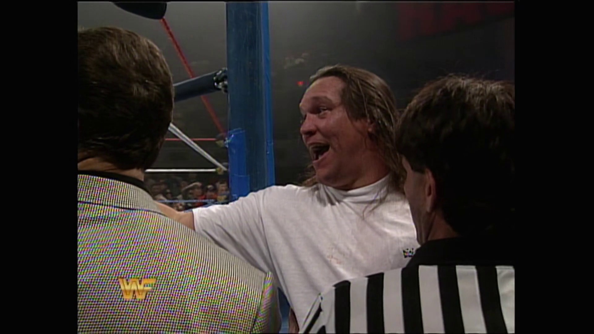A frame from WWE Raw (March 20, 1995) at 22:22. A wrestler in a white t-shirt celebrates enthusiastically in the wrestling ring, surrounded by other individuals. The WWF logo is visible in the lower left corner of the frame, with the blue ring post visible in the background.