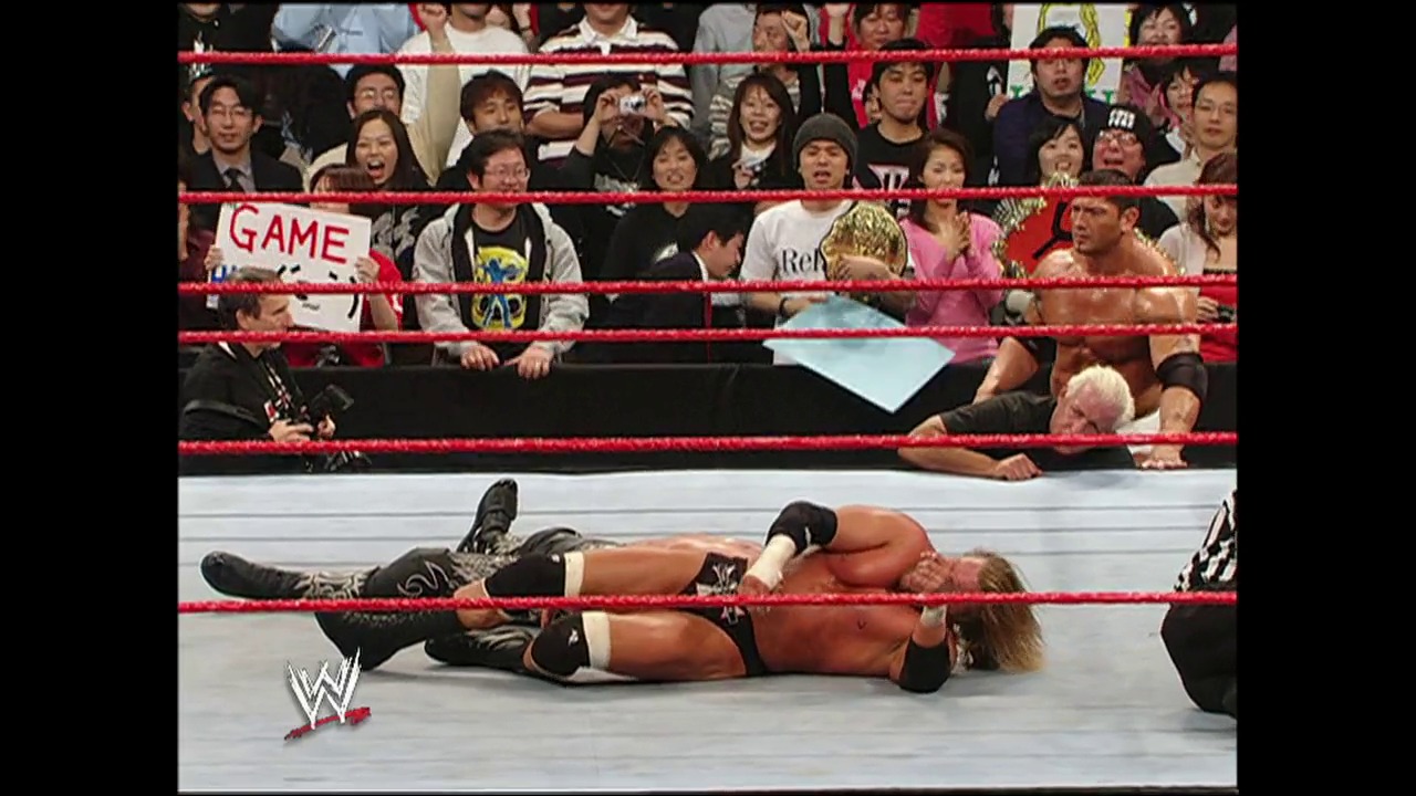 A frame from WWE Raw (February 7, 2005) at 1:35:29. A wrestler lies on the mat in a WWE Raw ring, appearing defeated or injured, while the crowd watches from behind the red ropes. The venue is filled with engaged spectators, and the WWE logo is visible in the corner.