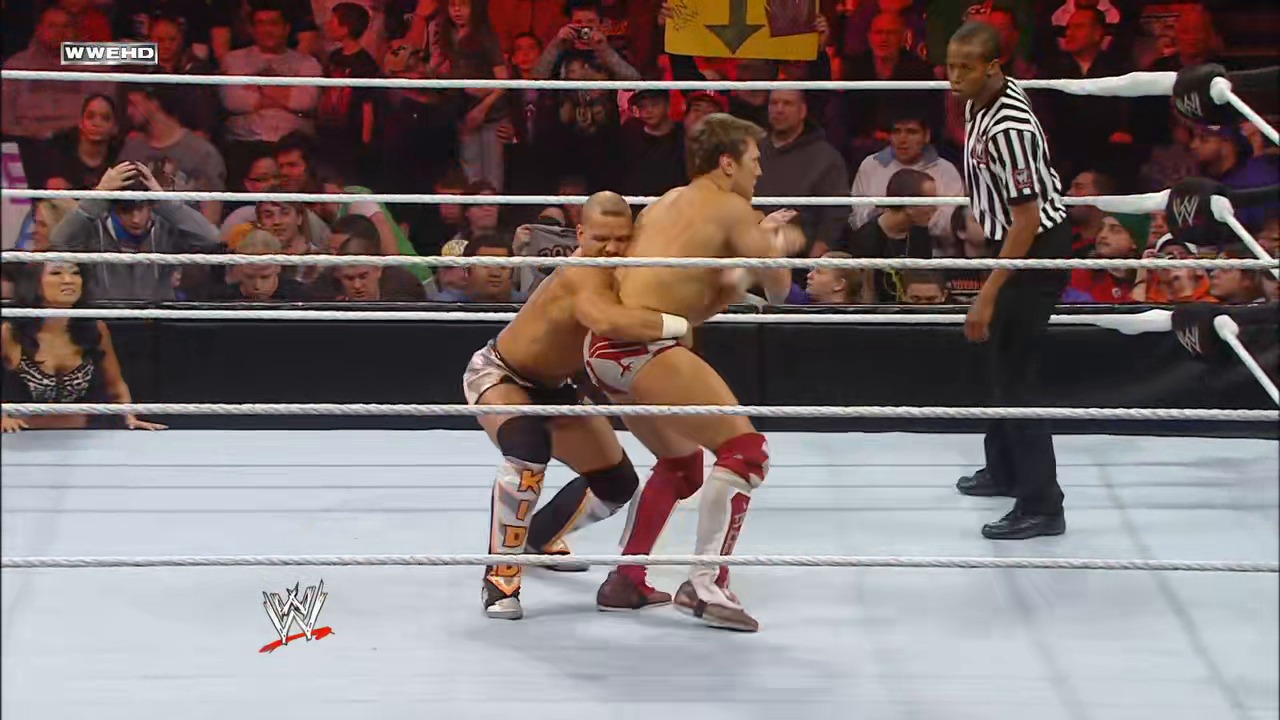 A frame from WWE Raw (January 31, 2011) at 38:11. Two wrestlers grapple in a WWE ring during an intense match, with a referee in striped shirt overseeing the action. The crowd watches from the stands while the WWE logo is visible on the mat, and the WWEHD watermark appears in the top left corner.