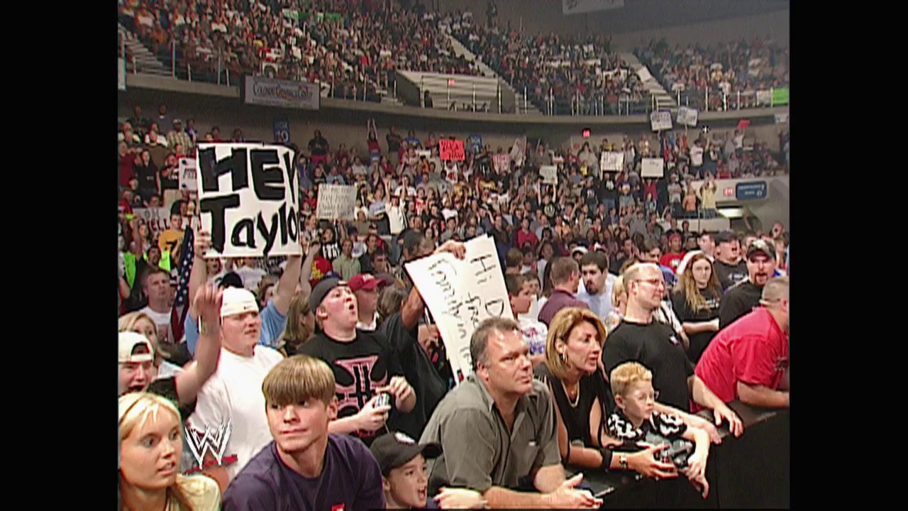 A frame from WWE Raw (September 8, 2003) at 40:39. A packed arena crowd holds signs and cheers during a WWE Raw event, with visible "HEY TAYLO" signage among the enthusiastic fans filling the stadium seats in the background.