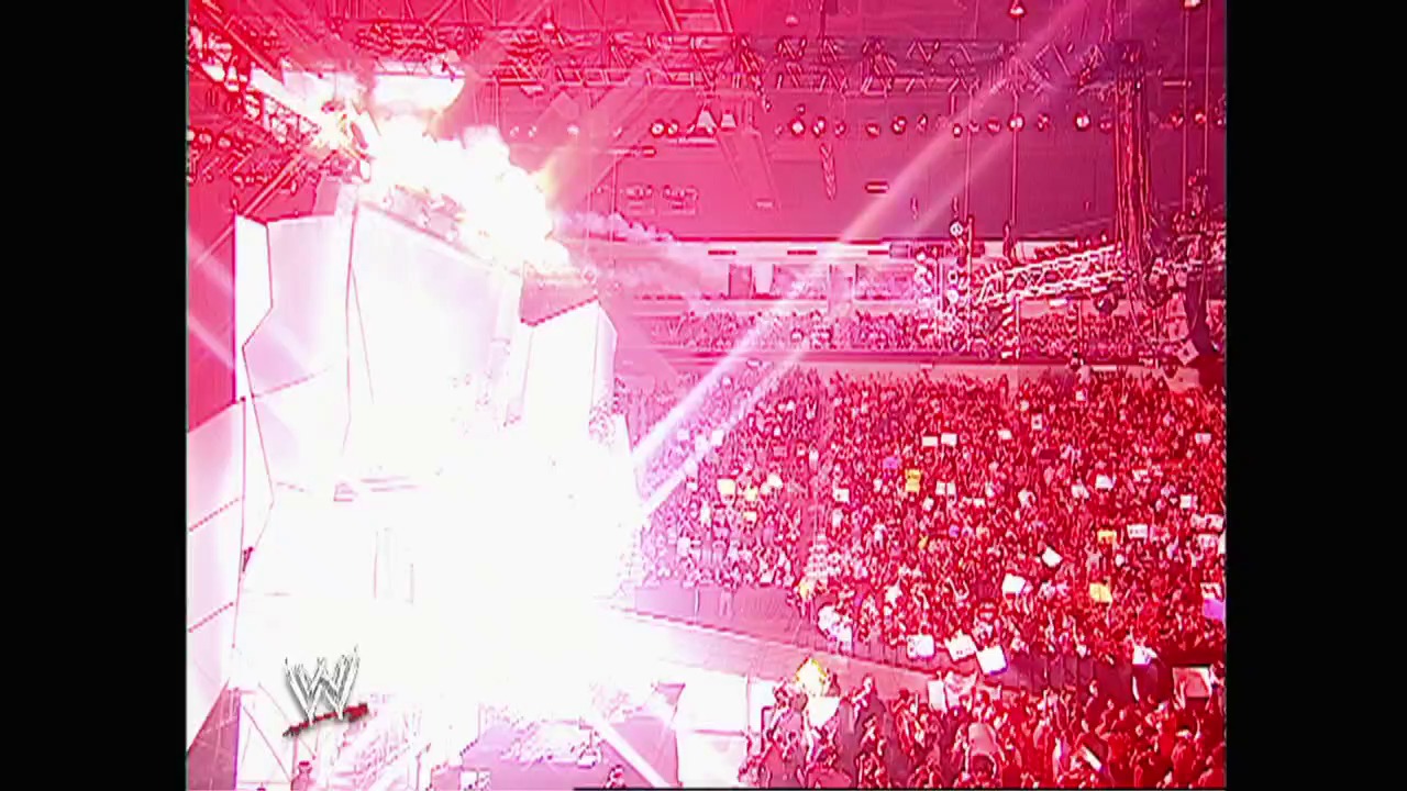 A frame from WWE Raw (March 14, 2005) at 0:48. A WWE arena filled with a massive crowd bathed in pink and red lighting, with the WWE logo visible in the lower left corner. The thermal or heat-map style imaging shows the packed stadium during a Raw event.