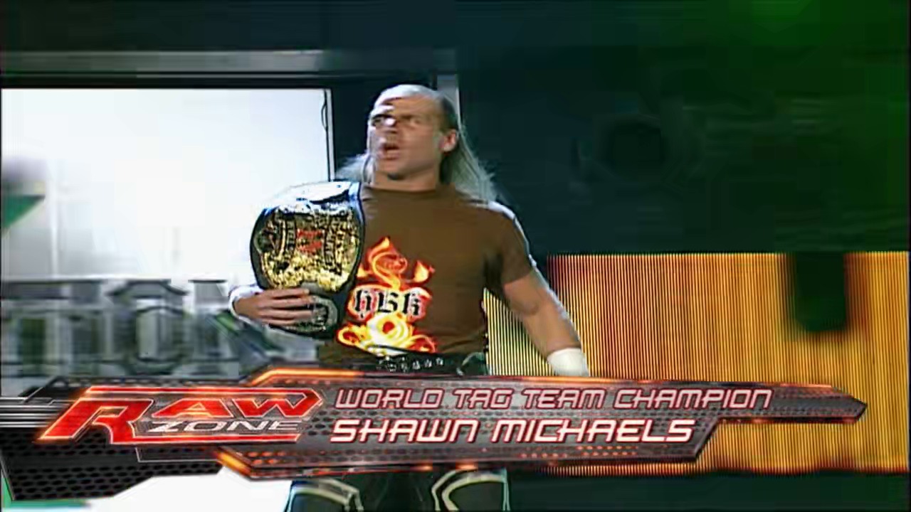 A frame from WWE Raw (March 19, 2007) at 1:14:20. A wrestler holding a World Tag Team Championship belt stands in the ring wearing a brown shirt with flame graphics. The wrestler is identified as Shawn Michaels via the on-screen graphic displaying his name and title.