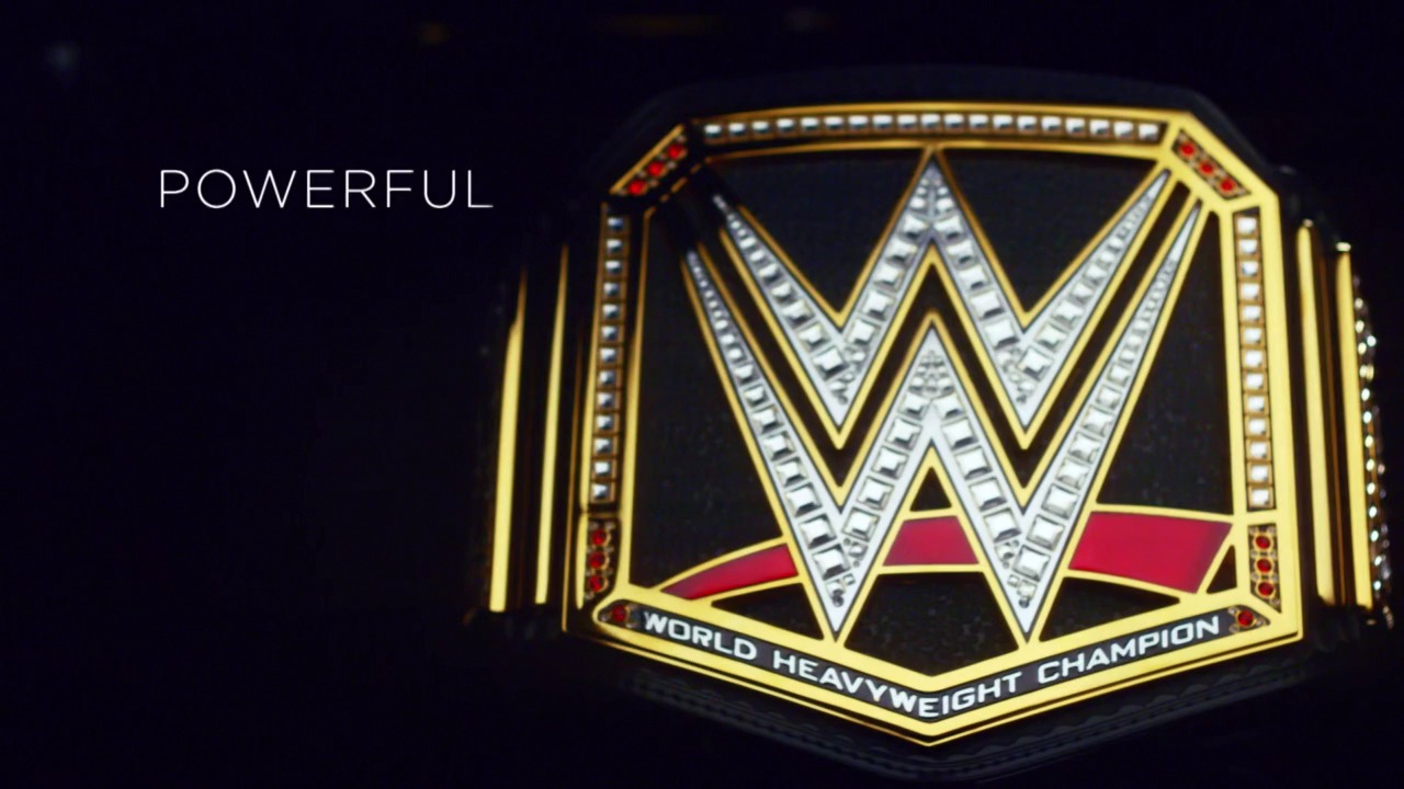 A frame from WrestleMania 38 (2022) at 1:06:30. A gleaming WWE World Heavyweight Championship belt is displayed against a dark background, featuring the iconic "W" logo in silver and gold with red accents. The word "POWERFUL" appears in white text on the left side of the frame.
