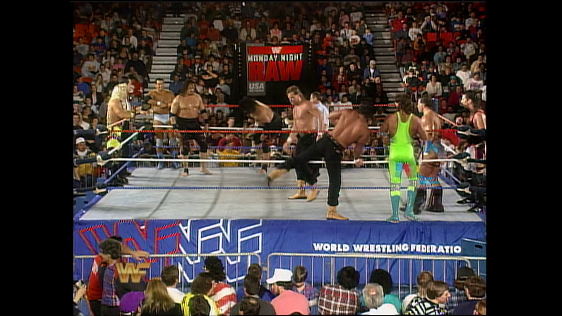 A frame from WWE Raw (April 4, 1994) at 27:58. # WWE Raw (April 4, 1994)

A wrestling match unfolds in the WWF ring with multiple shirtless wrestlers competing while a packed crowd watches from the stands. The blue-roped ring features the WWF and World Wrestling Federation logos, with a "Monday Night Raw" banner visible above the enthusiastic audience.