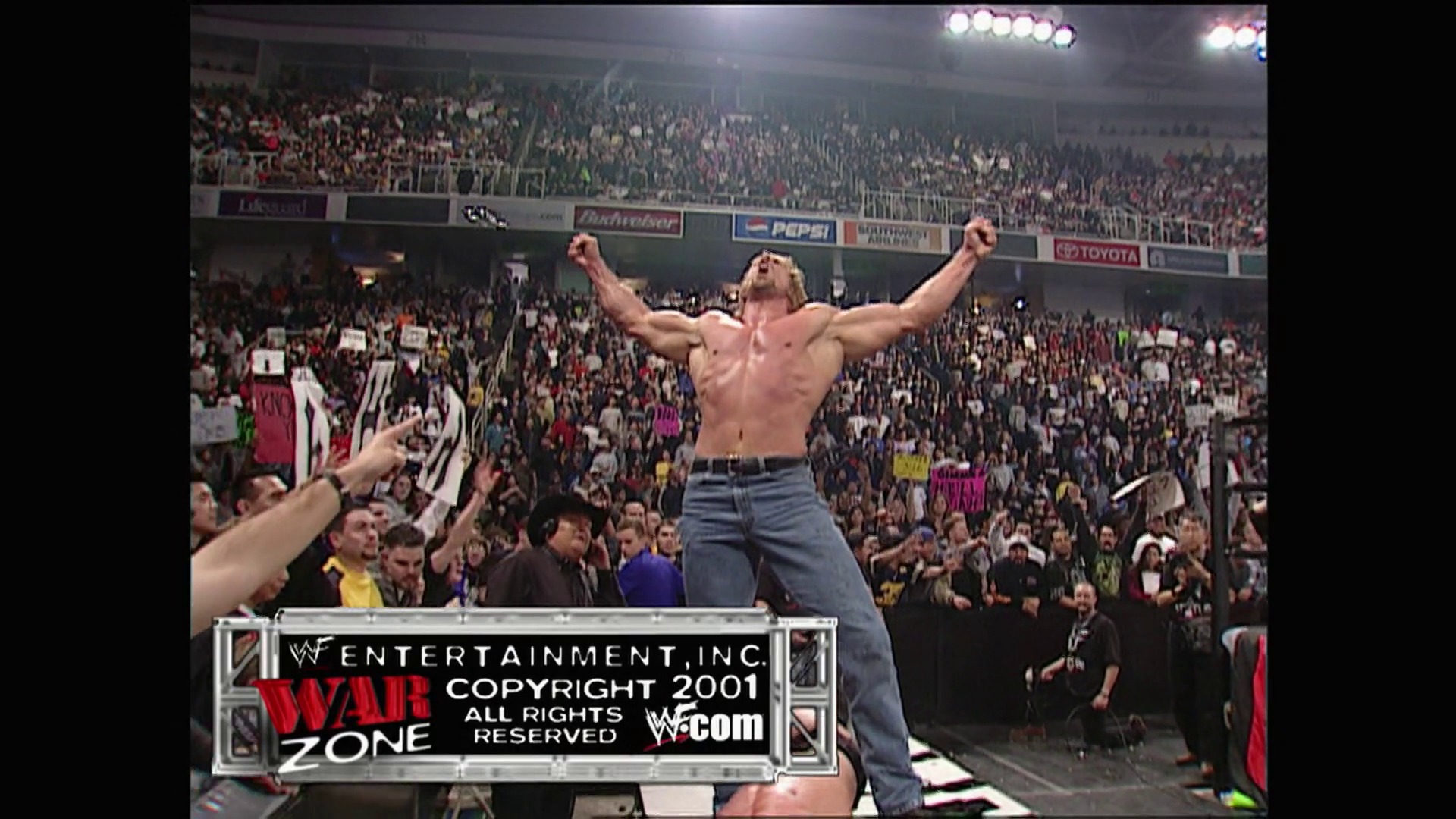 A frame from WWE Raw (January 8, 2001) at 1:40:49. A shirtless wrestler stands triumphantly with arms raised on the ring apron before a packed arena crowd. The WWF War Zone copyright graphic is displayed at the bottom of the screen, dated 2001.
