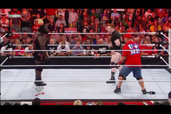 A frame from WWE Raw (August 29, 2011) at 38:17. Two wrestlers face off in a WWE Raw match inside the white-roped ring, with one wearing red and blue attire. The crowd fills the arena in the background, with "NEVER" visible on a banner above the ropes.