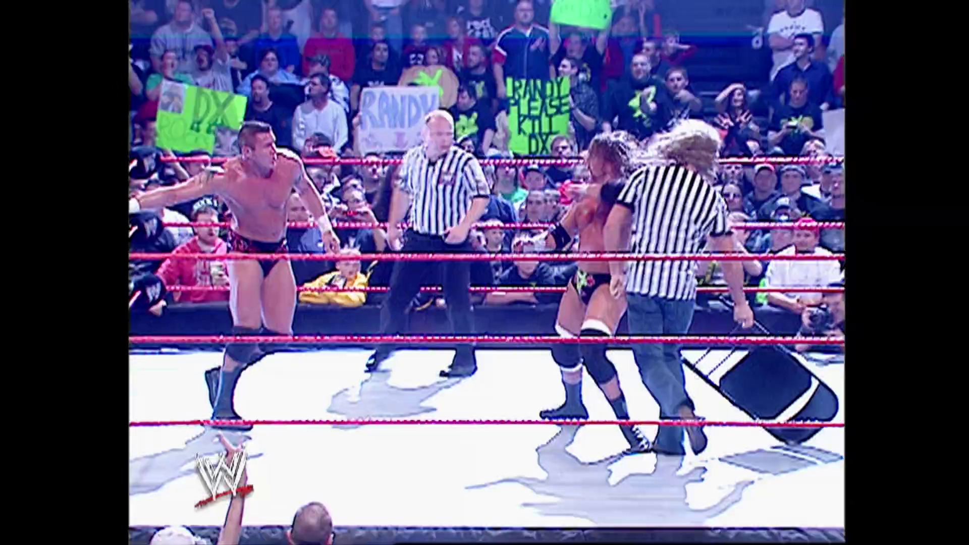 A frame from WWE Raw (October 30, 2006) at 50:17. A WWE Raw wrestling match in progress featuring two wrestlers in the red-roped ring with referees in striped shirts supervising. The crowd is visible in the background with bright neon green signs, and the WWE logo is displayed at the bottom of the frame.