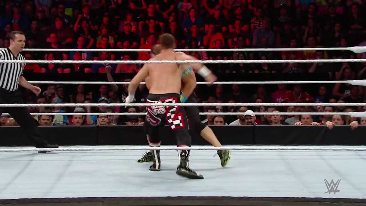 A frame from WWE Raw (May 4, 2015) at 1:38:17. A shirtless WWE wrestler in patterned black and red attire stands in the white wrestling ring during a match, with a referee in a striped shirt nearby and an enthusiastic crowd visible in the red-lit arena background.