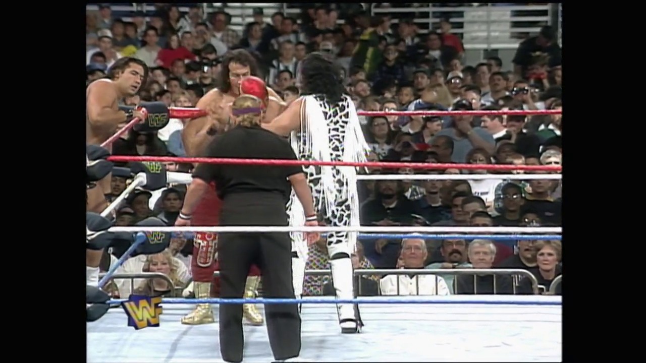 A frame from WWE Royal Rumble 1997 (1997) at 1:14:45. # WWE Royal Rumble 1997

A wrestler in a white and black leopard-print outfit stands in the WWF ring facing an opponent in black attire, while the crowd fills the arena behind them. The red and blue ropes frame the wrestling action as the WWF logo is visible in the corner.