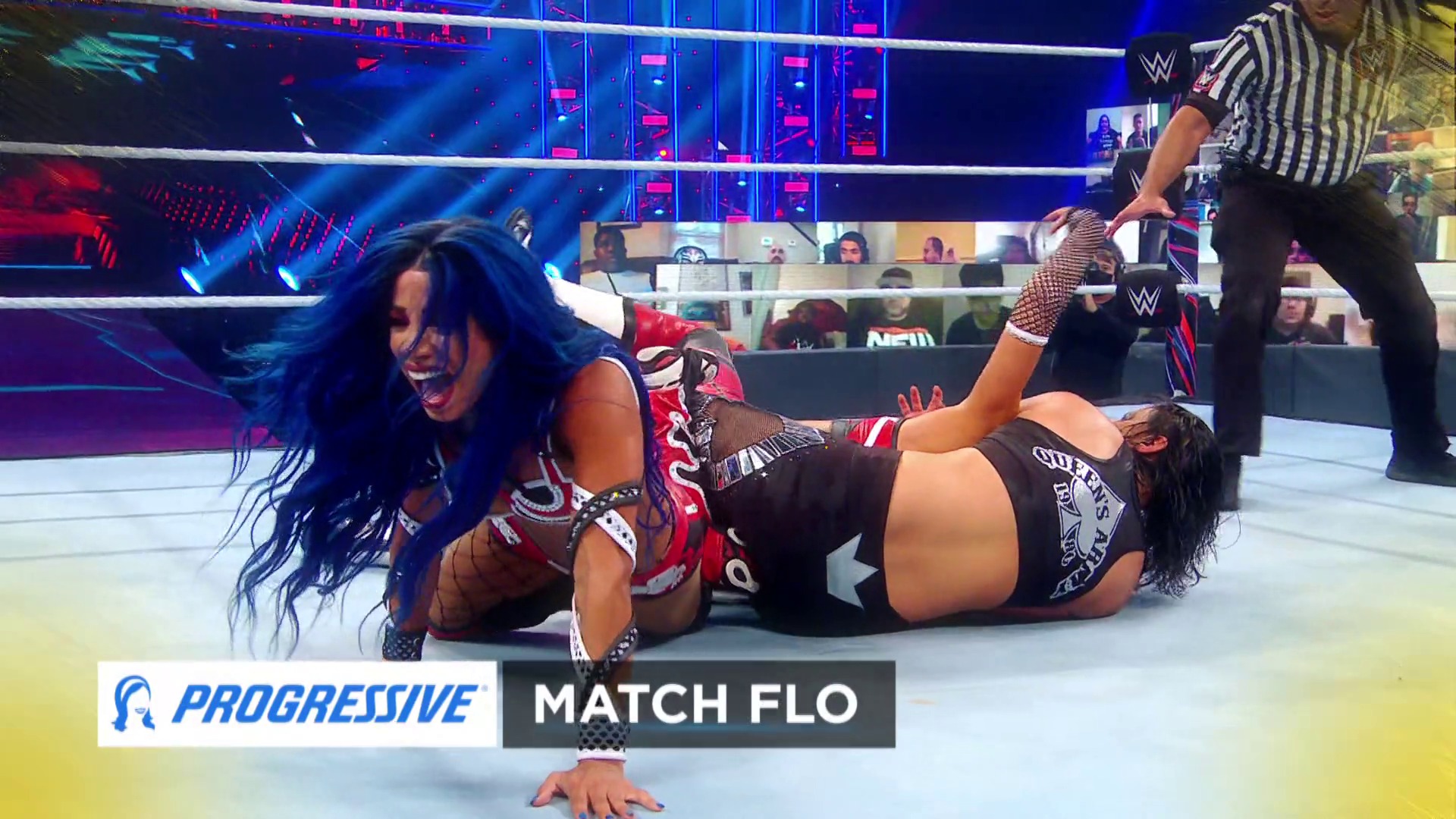 A frame from WWE SmackDown (September 4, 2020) at 30:06. # WWE SmackDown Match Description

Two female wrestlers compete in a WWE ring during a televised match, with one performer executing an offensive move while the other is grounded. The modern arena features dynamic blue and red lighting, digital screens displaying virtual audience members, and Progressive Insurance sponsorship branding visible at the bottom of the frame.