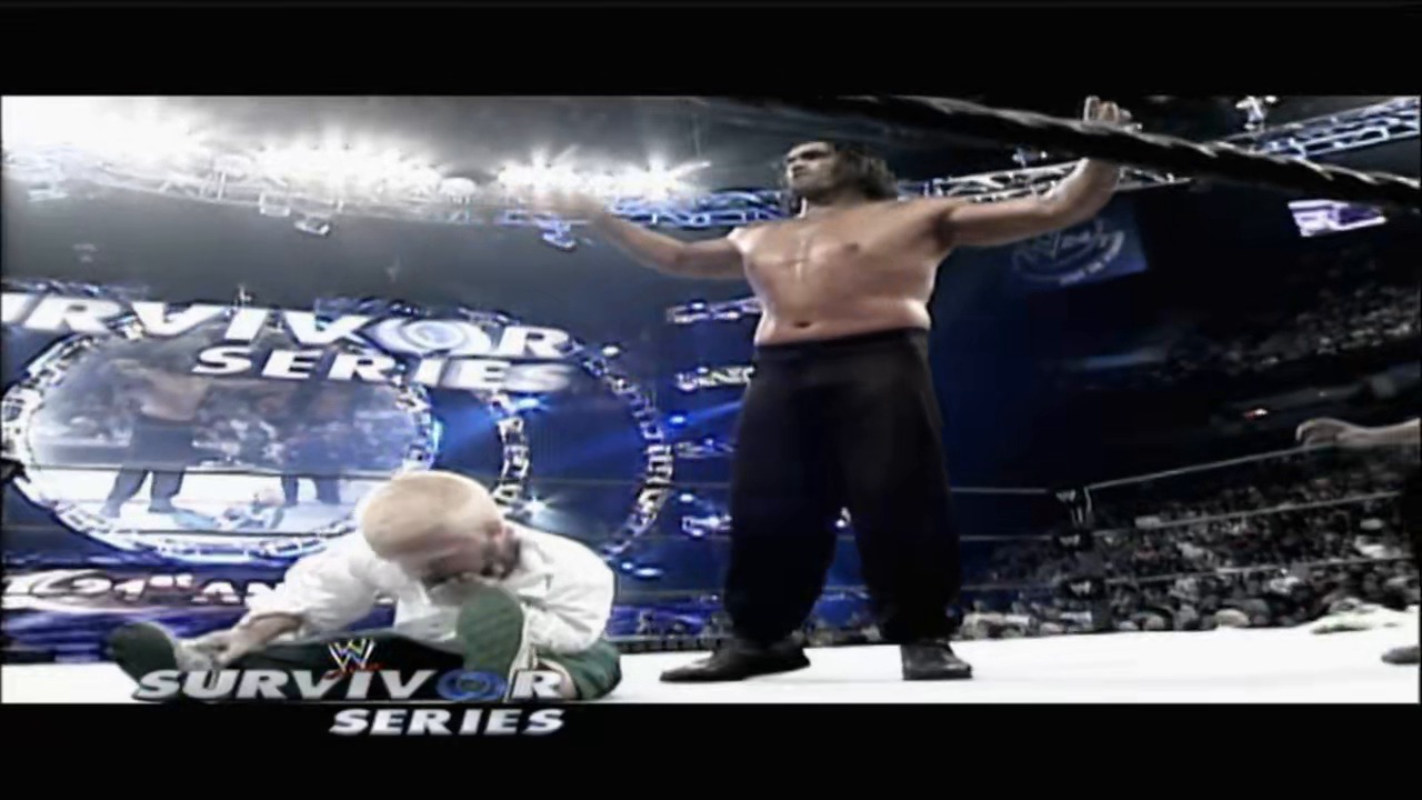 A frame from WWE Raw (November 19, 2007) at 26:23. # WWE Survivor Series Match

Two wrestlers are engaged in a match inside the ring during WWE Survivor Series. One wrestler stands on the top rope with his arms raised, while another competitor is positioned lower in the ring. The arena is packed with spectators, and blue WWE graphics and branding are visible around the ring perimeter.