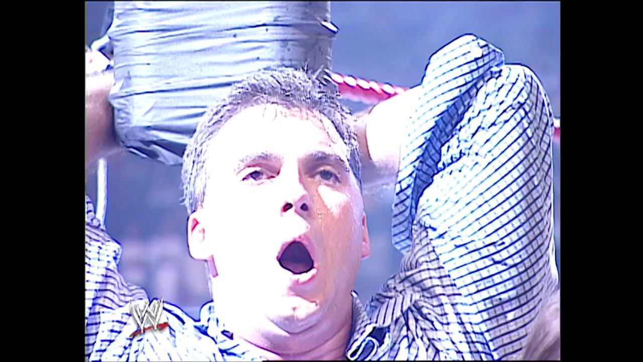 A frame from WWE Raw (September 1, 2003) at 51:46. A WWE wrestler with a surprised expression is captured mid-action, wearing blue and white striped attire with the WWE logo visible. The image has a characteristic early-2000s video quality with blue-tinted lighting effects typical of WWE Raw broadcasts from that era.