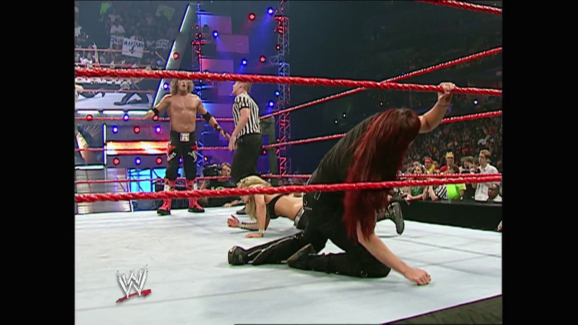 A frame from WWE Raw (August 7, 2006) at 45:39. A WWE wrestler with long red hair celebrates in the ring with their arm raised, while an opponent lies on the mat. A referee in a striped shirt oversees the match in the red-roped WWE Raw ring, with the crowd visible in the background.