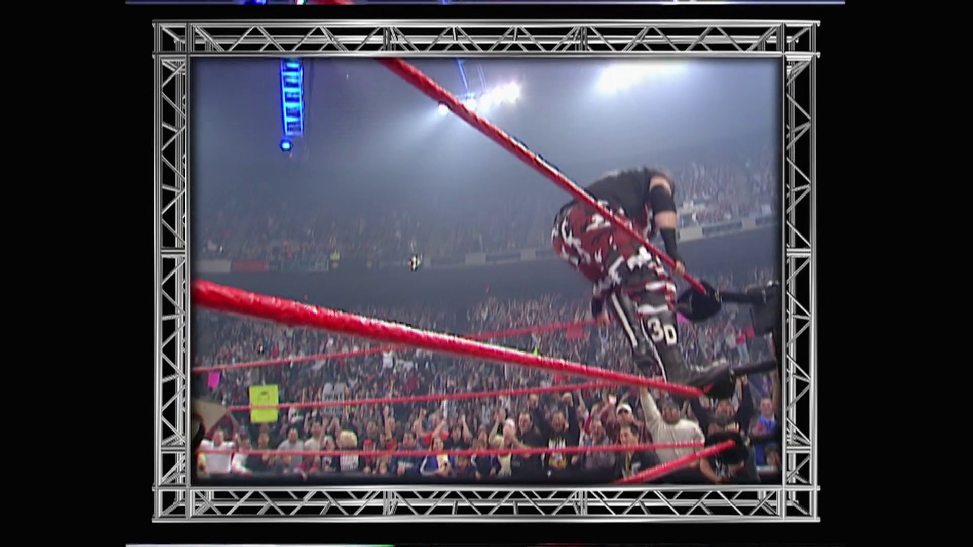 A frame from WWE Raw (January 1, 2001) at 54:50. A wrestler performs a high-flying maneuver from the top rope in a packed arena during WWE Raw, with red ropes framing the action and an enthusiastic crowd visible in the background under bright arena lighting.