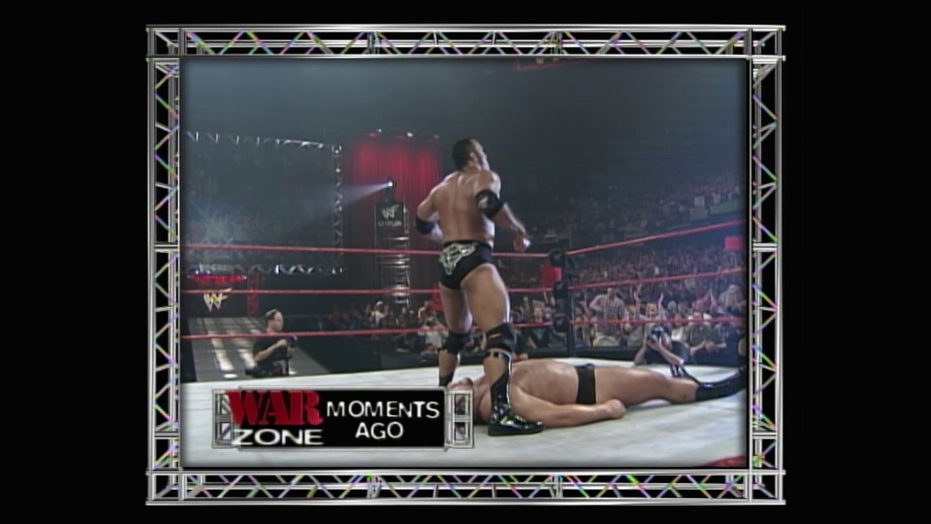 A frame from WWE Raw (August 9, 1999) at 1:26:01. A WWE wrestler stands victorious in the ring over a downed opponent during Raw, with a packed crowd visible in the arena. The "War Zone Moments Ago" graphic appears at the bottom of the broadcast screen.