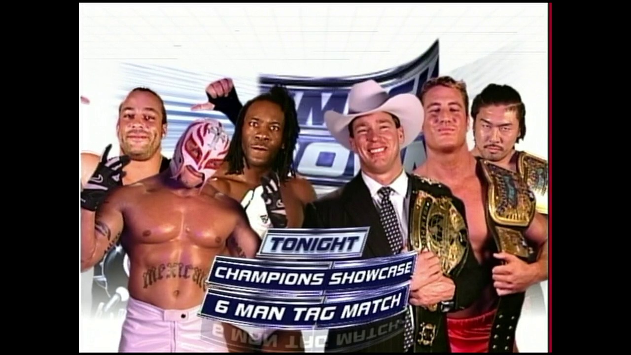 A frame from WWE SmackDown (October 21, 2004) at 37:00. A promotional graphic for WWE SmackDown's Champions Showcase featuring six wrestlers posing together, with text displaying "Tonight Champions Showcase 6 Man Tag Match" overlaid on the image against a blue and white branded background.