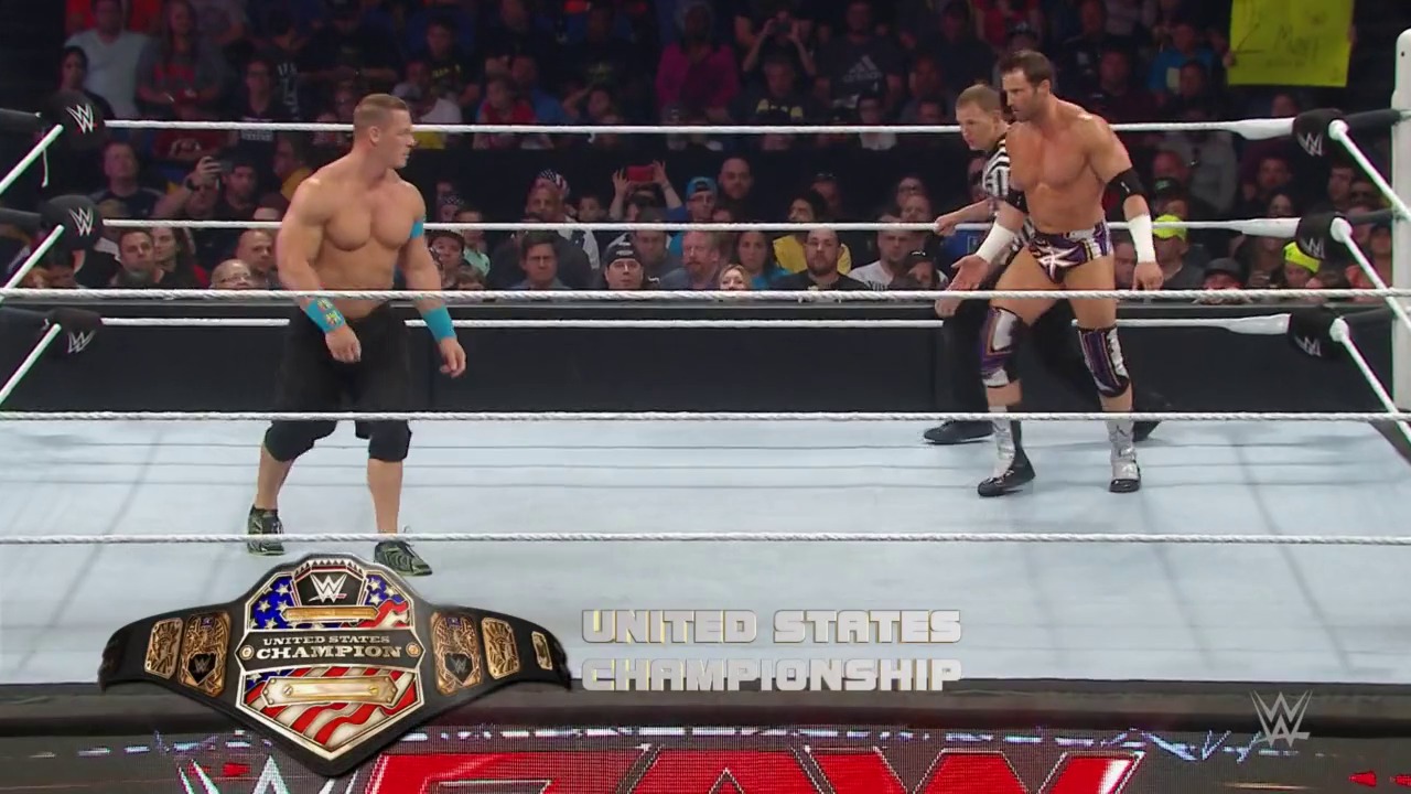 A frame from WWE Raw (May 25, 2015) at 1:36:02. Two WWE wrestlers face off in the ring during a United States Championship match, with a referee between them and an enthusiastic crowd visible in the background. The championship belt is prominently displayed at the bottom of the frame.