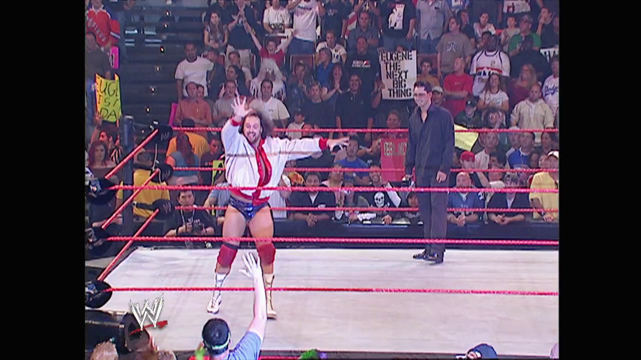 A frame from WWE Raw (May 17, 2004) at 53:34. # WWE Raw Match Scene

A wrestler in white and red attire celebrates in the ring with raised arms while an official stands nearby. The red-roped WWE ring is surrounded by an enthusiastic crowd, with visible signage and the WWE logo displayed at ringside.