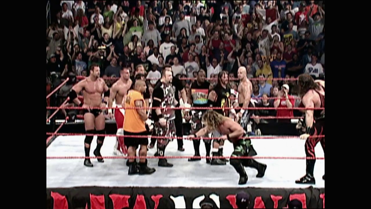 A frame from WWE SmackDown (July 12, 2001) at 0:47. Multiple wrestlers are positioned in a WWE ring during an active match, with a packed crowd visible in the background. The red ropes and branded graphics frame the white canvas where the competitors are engaged.