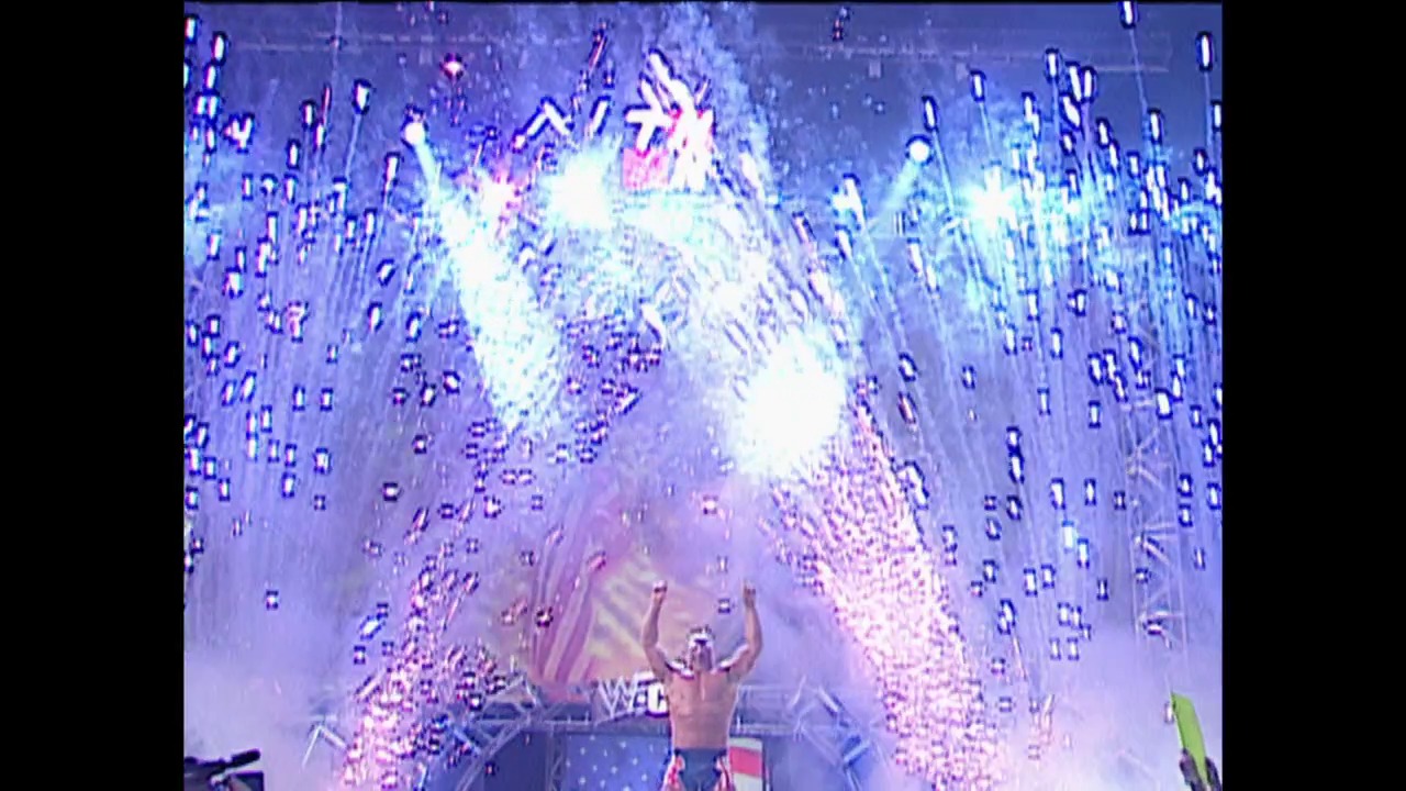 A frame from WWE SmackDown (September 20, 2001) at 0:06. A shirtless wrestler stands in the ring with arms raised as pyrotechnics explode overhead, creating a spectacular burst of white and purple light. The dramatic special effects and lighting create an intense, celebratory atmosphere typical of professional wrestling entertainment.