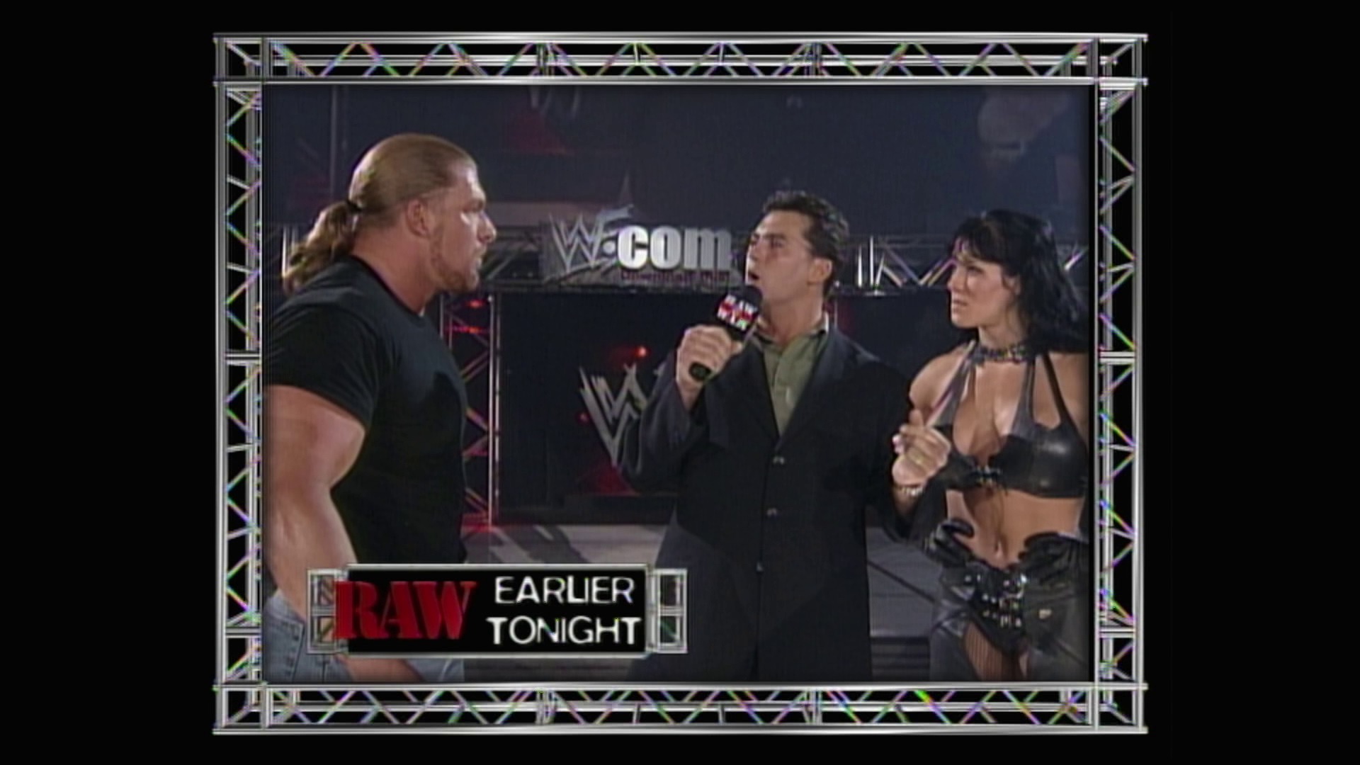A frame from WWE Raw (August 23, 1999) at 1:18:35. A WWE Raw backstage interview segment features a blonde wrestler in black attire facing two suited interviewers and a female performer. The WWE.com logo and "RAW EARLIER TONIGHT" graphic are visible at the bottom of the screen.