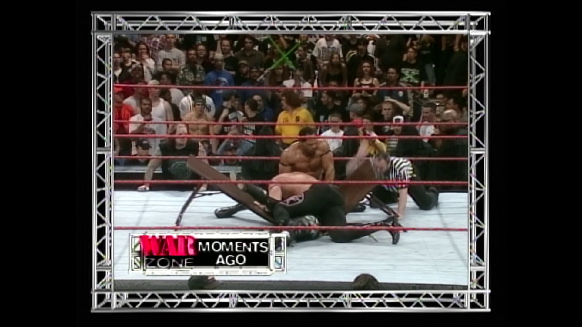 A frame from WWE Raw (February 1, 1999) at 1:13:39. A wrestler is pinned on the mat during a WWE Raw match, with a referee in striped shirt overseeing the action. The crowd fills the arena seats behind the red ropes, while the "Raw Moments Ago" graphic displays at the bottom of the screen.