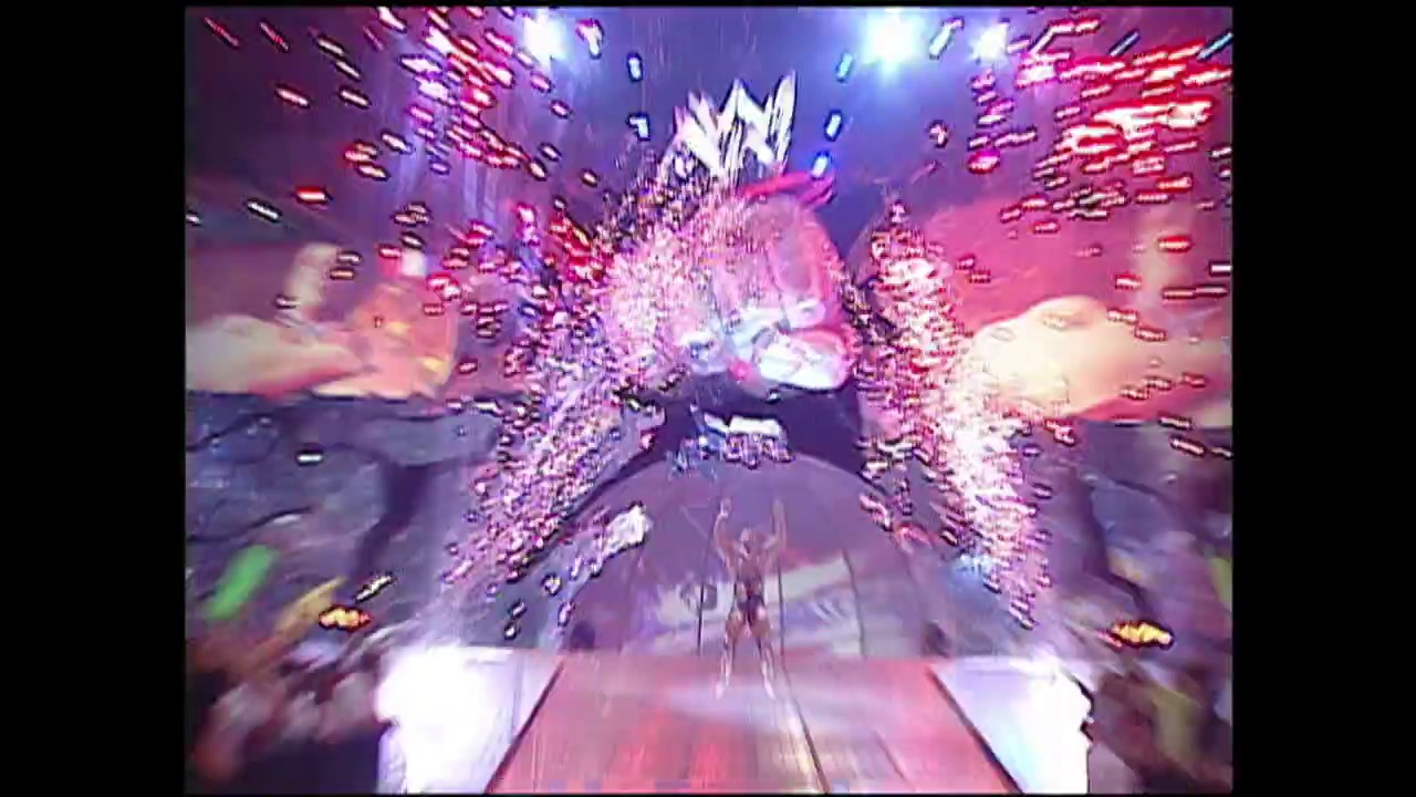 A frame from WWE SmackDown (March 6, 2003) at 0:37. # WWE SmackDown Visual Description

A dynamic first-person perspective shot through a tunnel of pink and purple pyrotechnic effects and digital graphics, with bright white flashes and sparkling elements creating an intense entrance sequence typical of early 2000s WWE production.